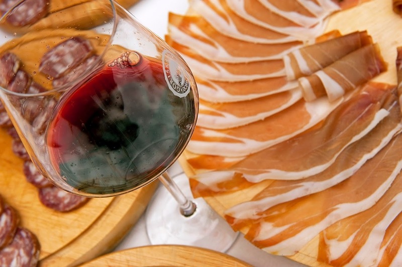 narezan kraški pršut in kozarec rdečega vina